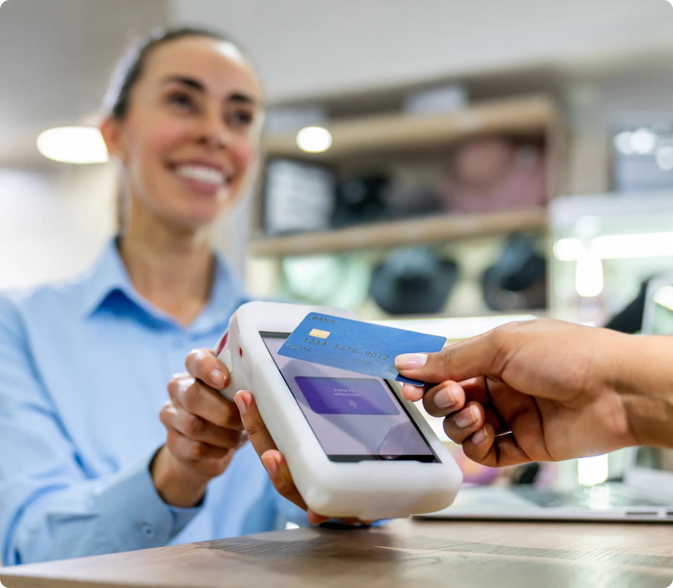 Smiling cashier holding payment terminal
