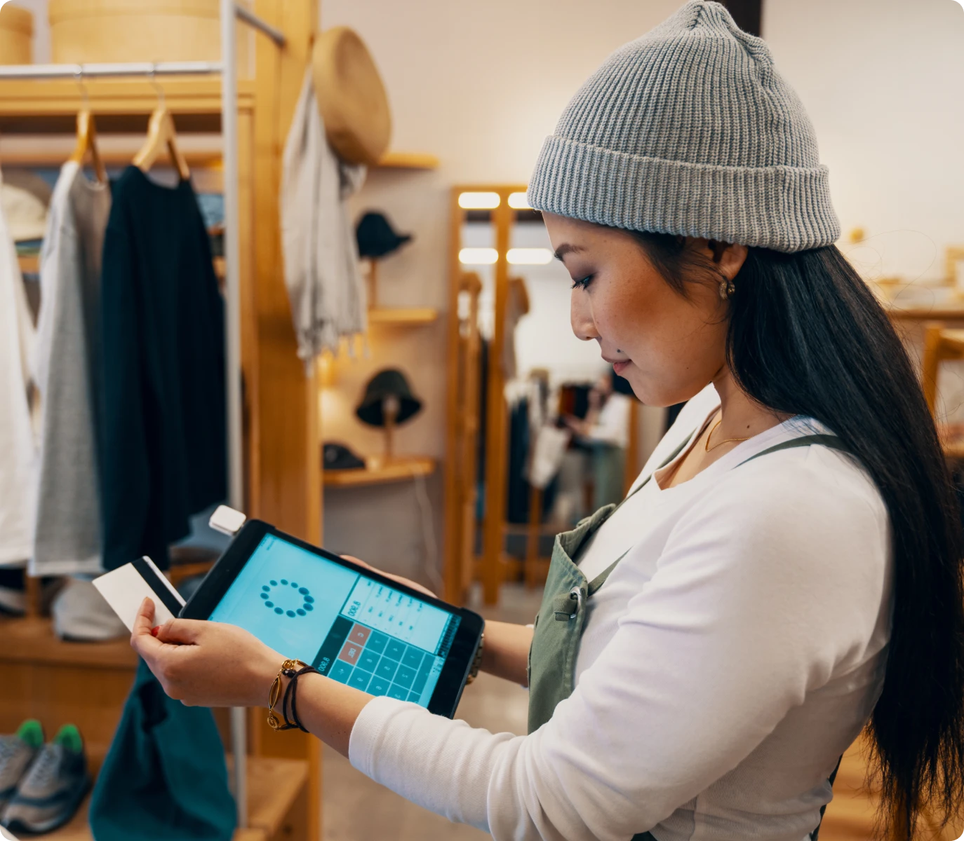 Woman processing transaction in clothing store