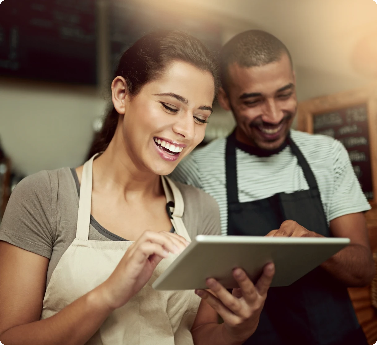 Smiling baristas with a digital device